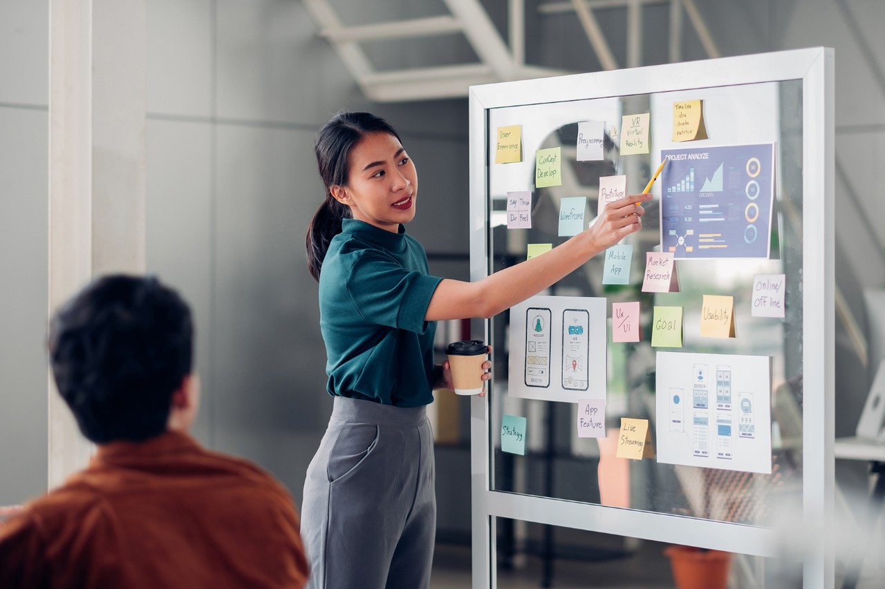 Une femme présentant des informations sur un tableau à un homme