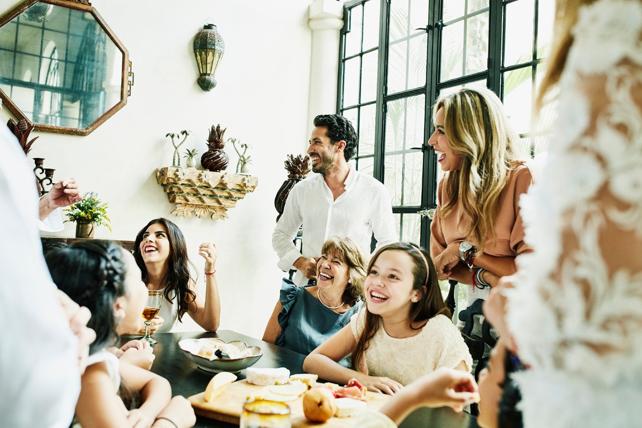 Un groupe de 10 personnes riant autour d'une table