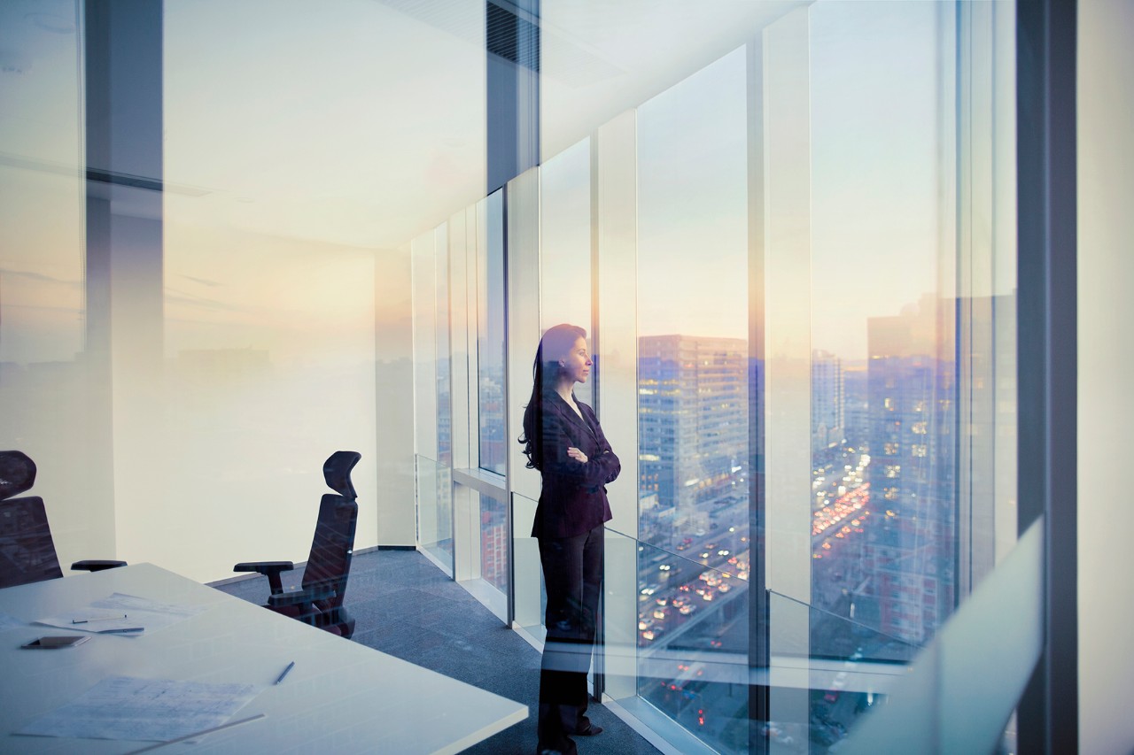Businesswoman in conference meeting room looking by the window